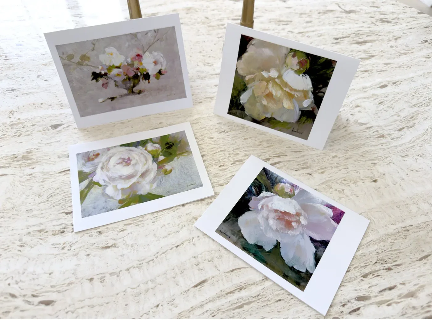 Greeting cards printed with white peony paintings, arranged on a pale stone surface